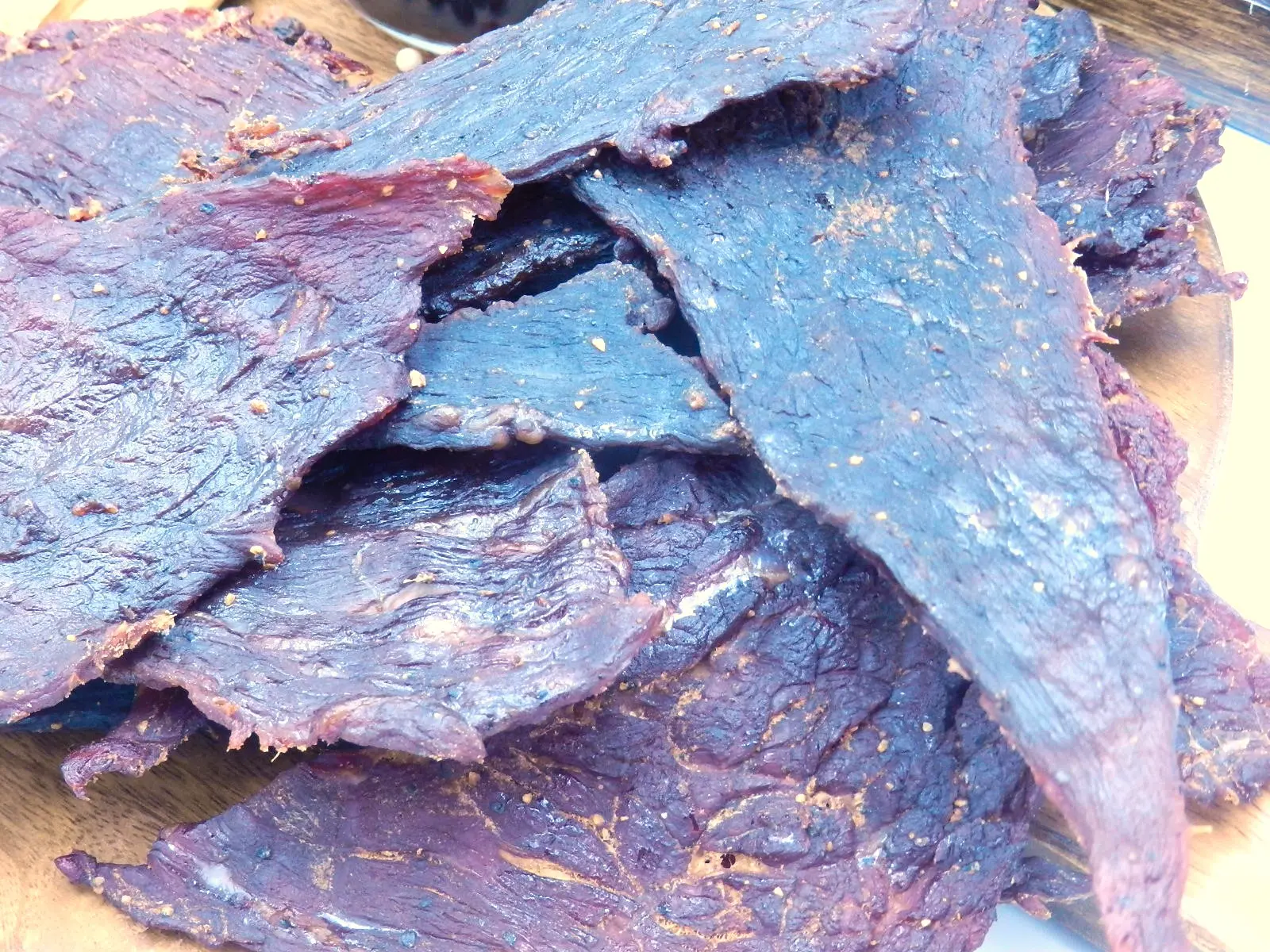Slices of beef jerky on a wood background